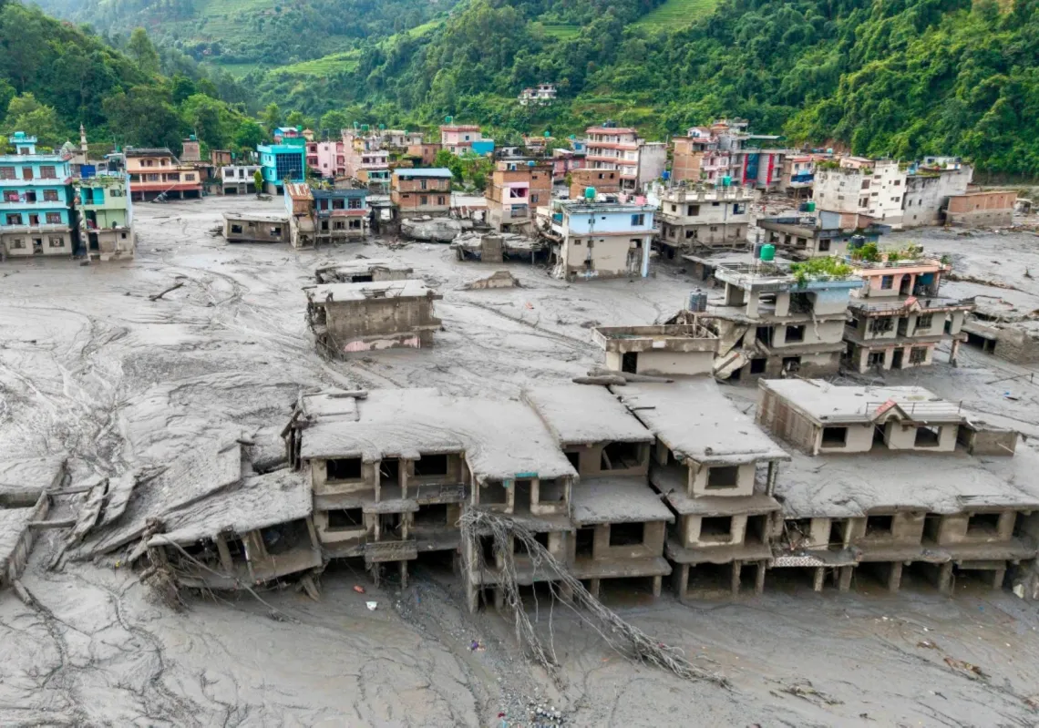 An aerial view shows houses lying deluged in sludge after flash floods in Devighat, Bidur Municipality, Nepal's Nuwakot district, on 27 August 2026.