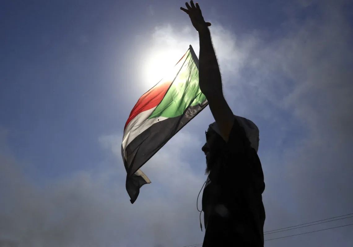 متظاهر سوداني مناهض للانقلاب يلوح بالعلم الوطني خلال مظاهرة شرقي الخرطوم، في 25 نوفمبر 2021