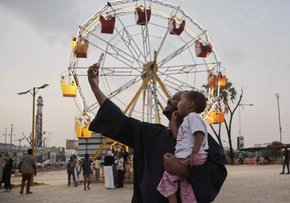 رجل يلتقط صورة مع ابنه في مدينة ملاهٍ بالخرطوم، السودان، في 5 سبتمبر 2026