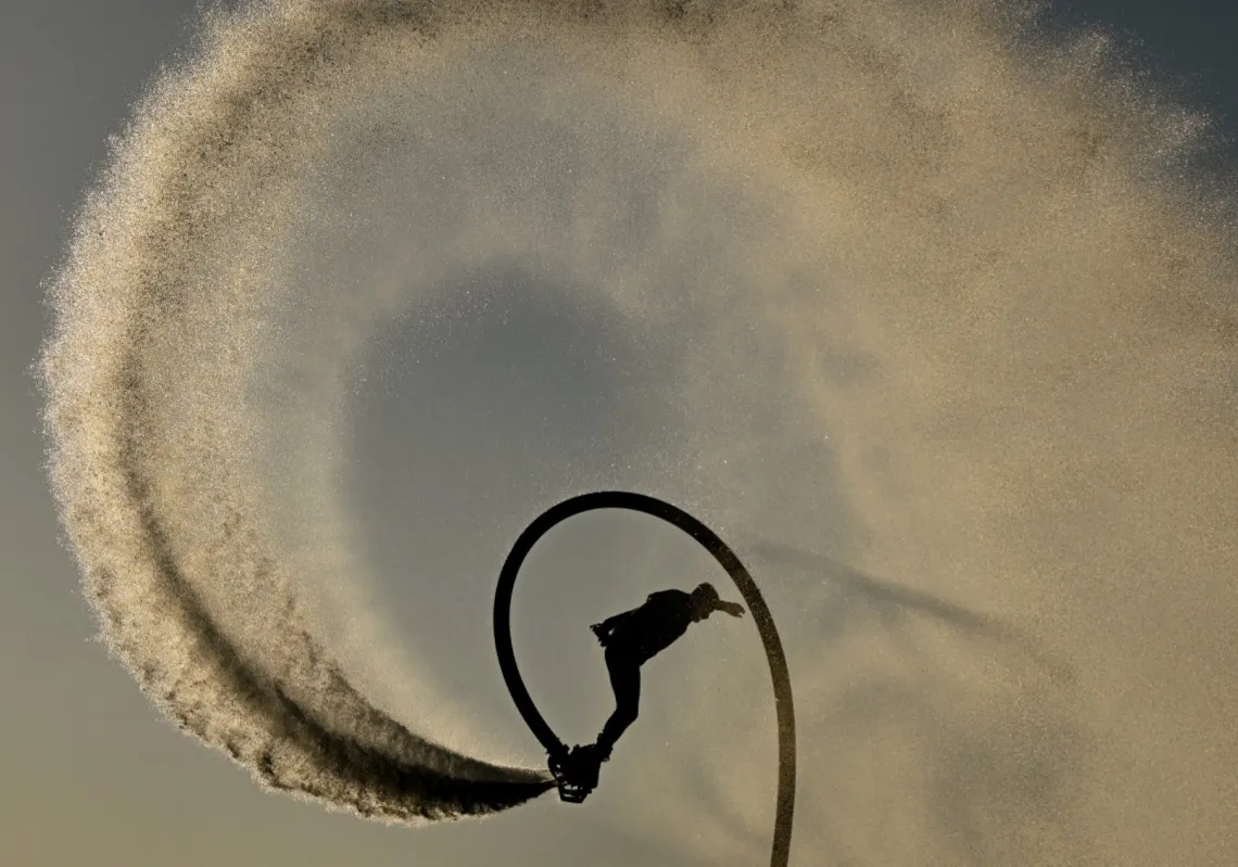 A youth performs on a flyboard in the waters of the Shatt al-Arab River near the Mohammed Baqir al-Sadr Bridge in the southern Iraqi city of Basra on 4 September 2026. 