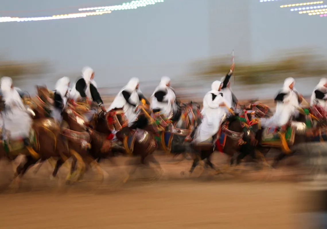 فرسان يرتدون أزياء تقليدية يمتطون خيولهم خلال عرض لفرقة الميز في حفل زفاف ليبي في بنغازي، ليبيا، 4 سبتمبر