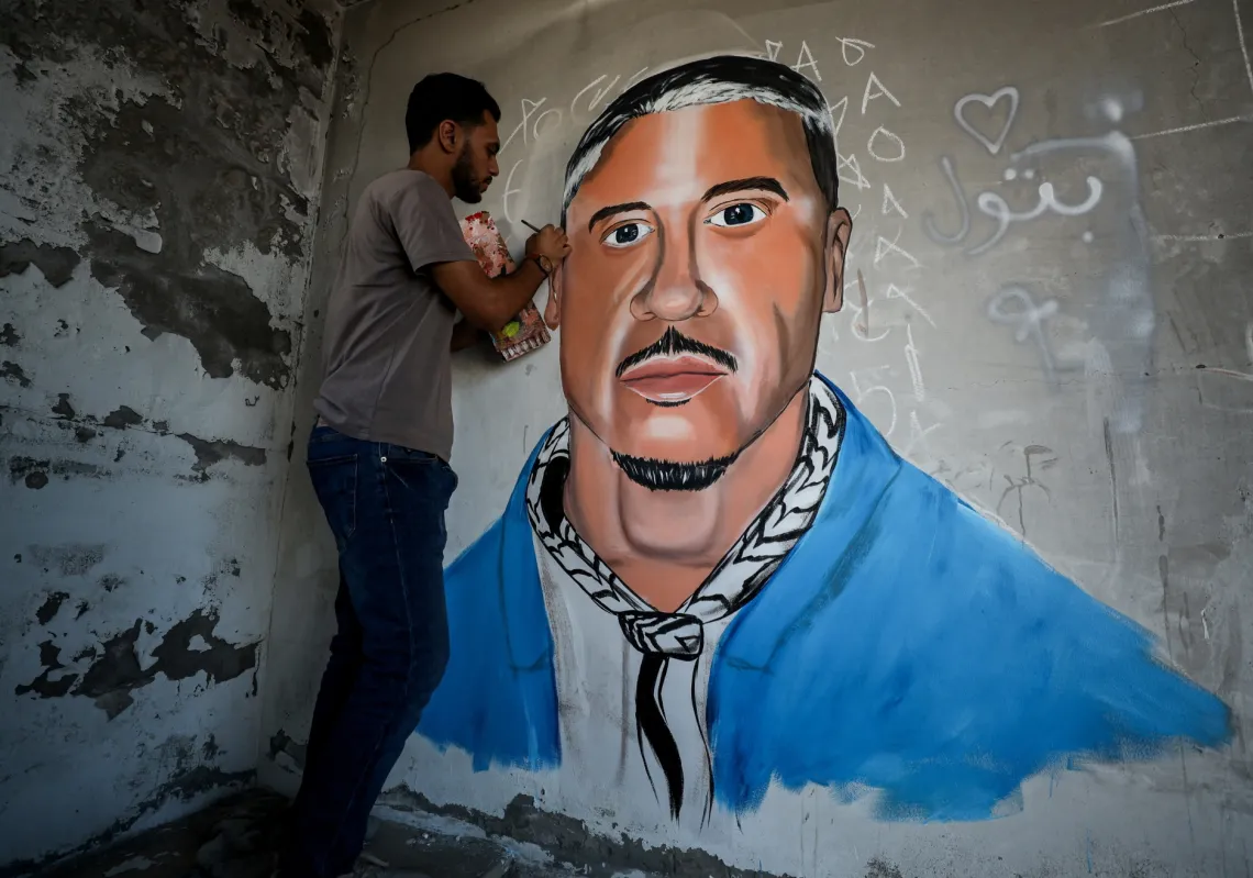 A Palestinian artist paints a mural honouring US rapper Macklemore on a building damaged during the war, in Gaza City, on 19 September 2026. 