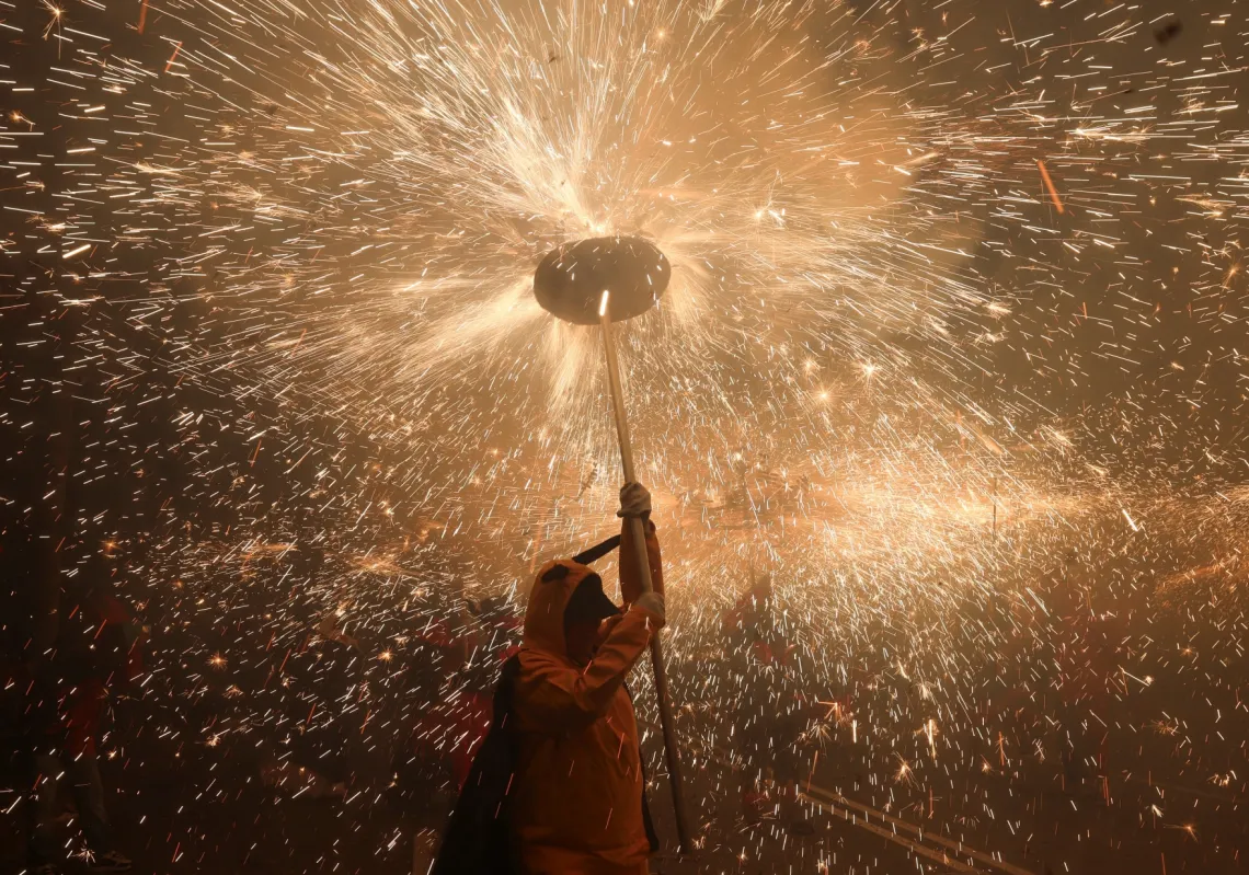 A performer holds a stick with fireworks during the traditional "Correfoc" (fire run) as part of the La Mercè festival, which celebrates Barcelona's patron saint, in Barcelona, Spain, on 26 September 2026.