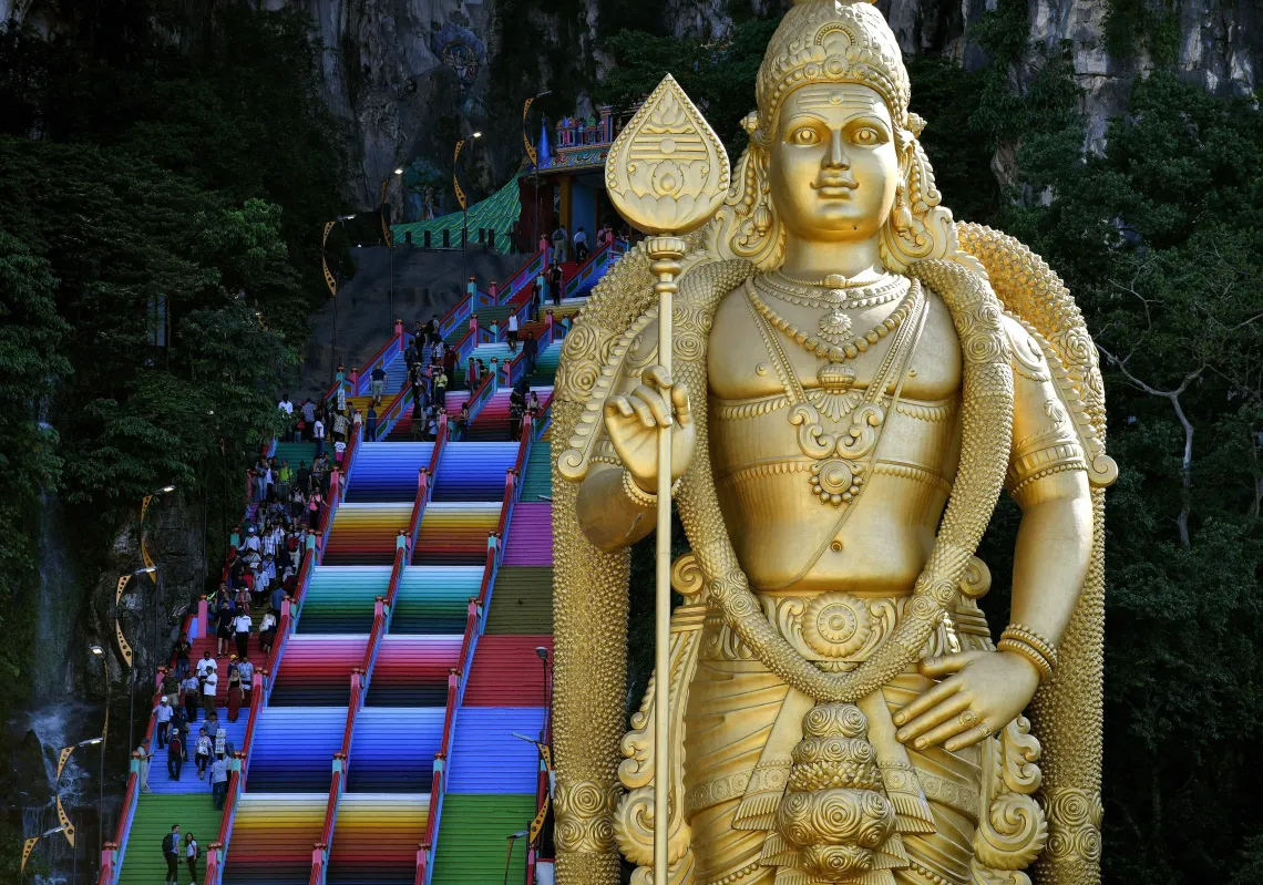 Visitors walk up the newly-painted 272-steps staircase leading to Malaysia's Batu Caves Hindu temple in Kuala Lumpur on August 30, 2018. (Getty)
