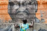 A woman mourns next to a mural depicting the late former Kenyan Prime Minister Raila Odinga, on the day he died, in the Kibera slum in Nairobi, Kenya, on October 15, 2025.  REUTERS/Monicah Mwangi